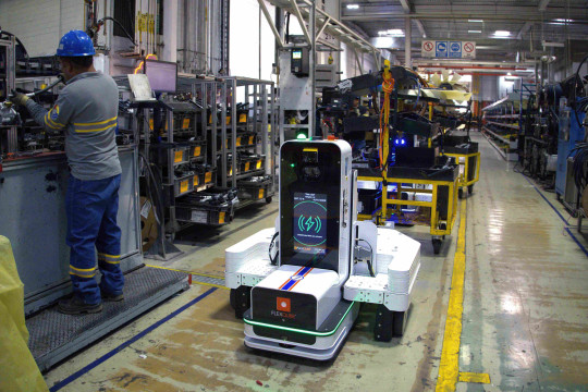 Laden im Takt der Produktion: Während die Mitarbeiter an der Montagelinie arbeiten, lädt sich der Flexqube-Roboter automatisch am integrierten Ladepunkt – ohne zusätzliche Ladepause. (Bildquelle: Wiferion - a PULS business unit)