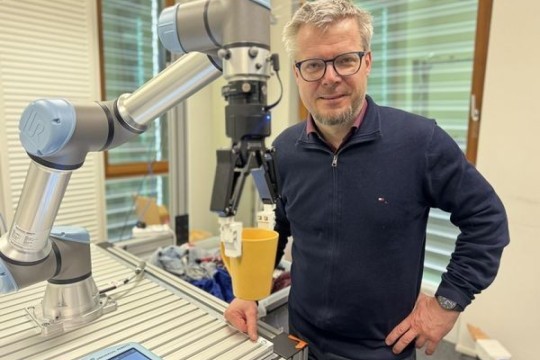 Hubert Zangl (Institut für Intelligente Systemtechnologien) mit dem Robotergreifer (Quelle: aau/Müller)