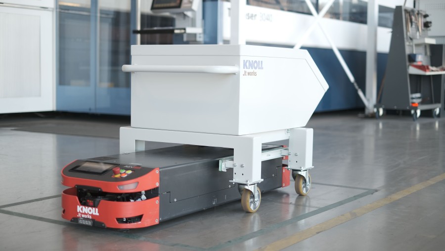Die Fahrzeuge von Safelog lassen sich beim innerbetrieblichen Transport auch zusammen mit Trolleys nutzen. Bei dieser Applikation kommen die schleppenden Fahrzeuge zum Einsatz, die im Vergleich zu den aushebenden Modellen bei der Hardware im Stückpreis günstiger sind. (Bildquelle: Safelog)