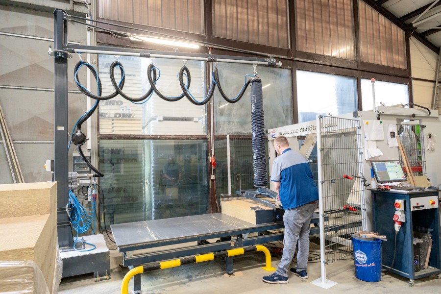 Ergonomics in focus: With the Timmer hose lifter, Matthias Vogelsang places heavy rock wool panels into the CNC cutting machine efficiently and precisely. (Image source: Timmer GmbH)